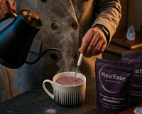 Person pouring a hot beverage into a mug with RestEase packaging in the background