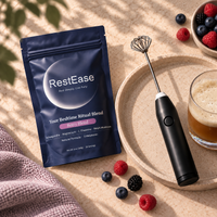 A RestEase sleep supplement pouch labeled 'Your Bedtime Ritual Blend' is styled on a beige tray with a handheld electric frother, a glass of iced coffee, and berries on a sunlit tabletop.